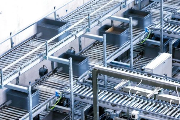 Conteneurs RAKO transport&eacute;s sur un syst&egrave;me de convoyage complexe