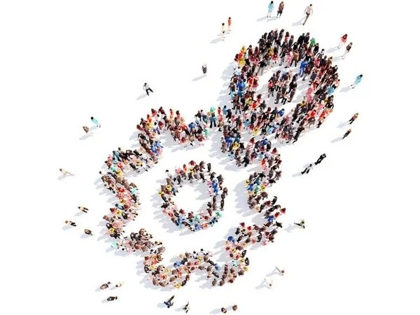 Foto de dron de muchas personas que juntas forman dos engranajes que engranan